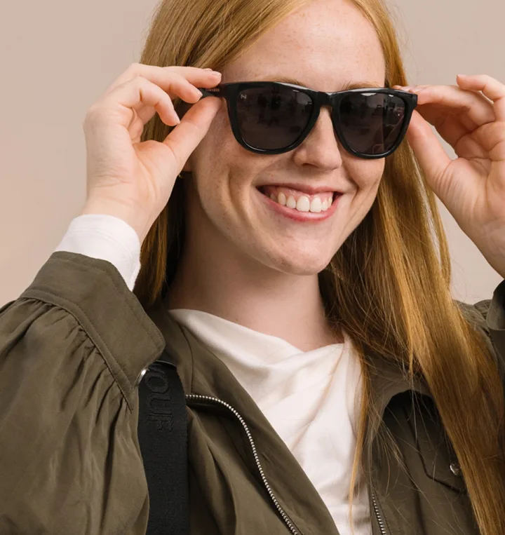 Femme souriante avec des lunettes de soleil