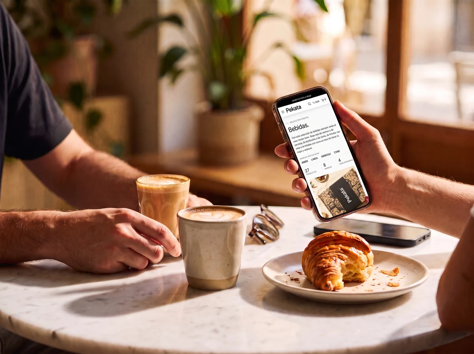 Zwei Personen beim Kaffee, die das Pekata-Portal auf einem Smartphone ansehen